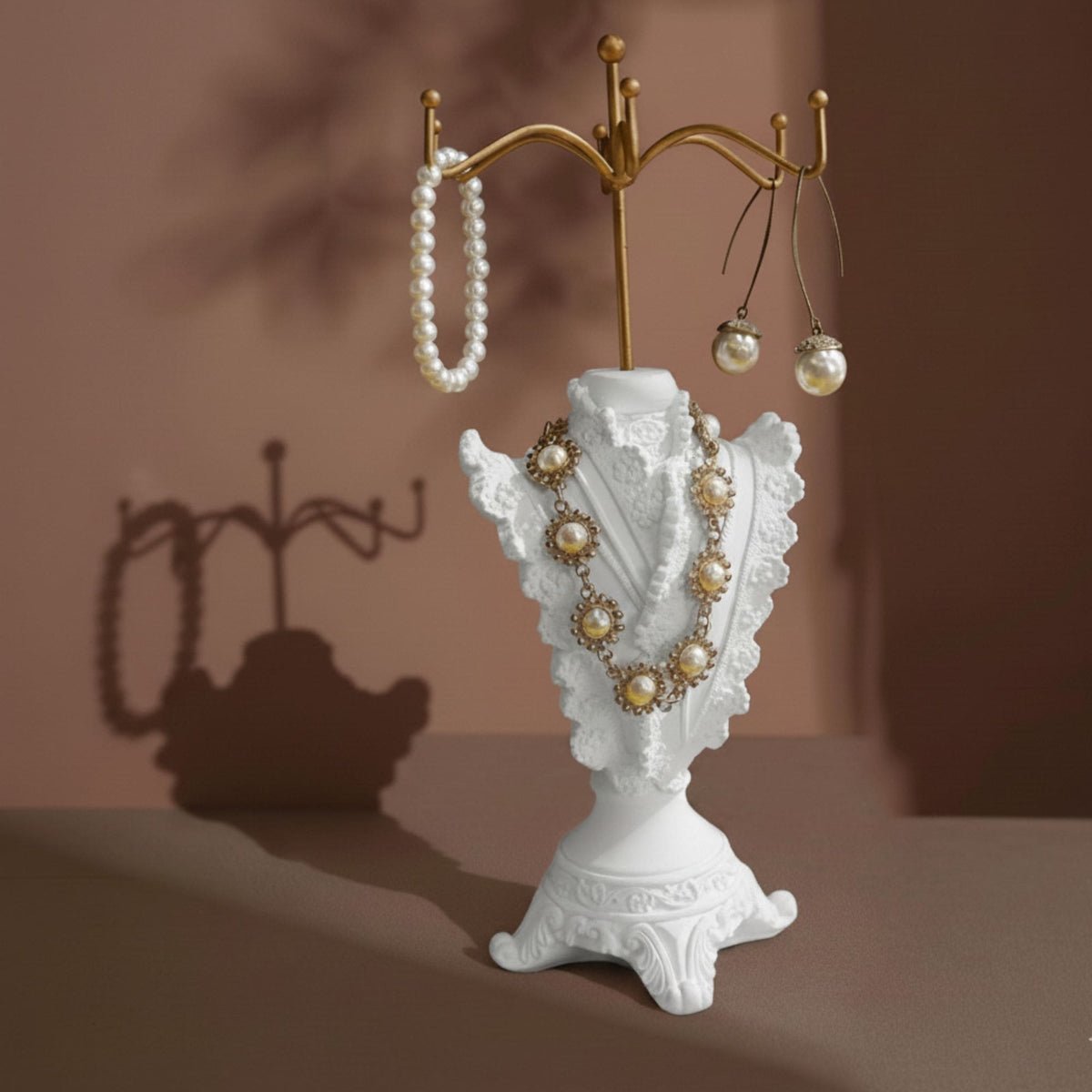 Ivory dress-form jewelry display stand with pearl necklace and earrings on a vanity