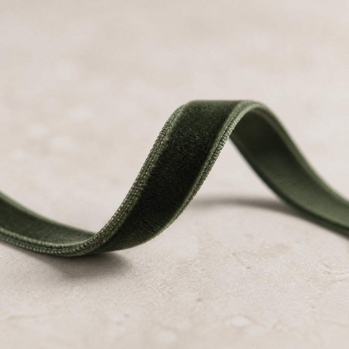 Macro detail showing the plush velvet pile on both sides of narrow Deep Jade Green ribbon.