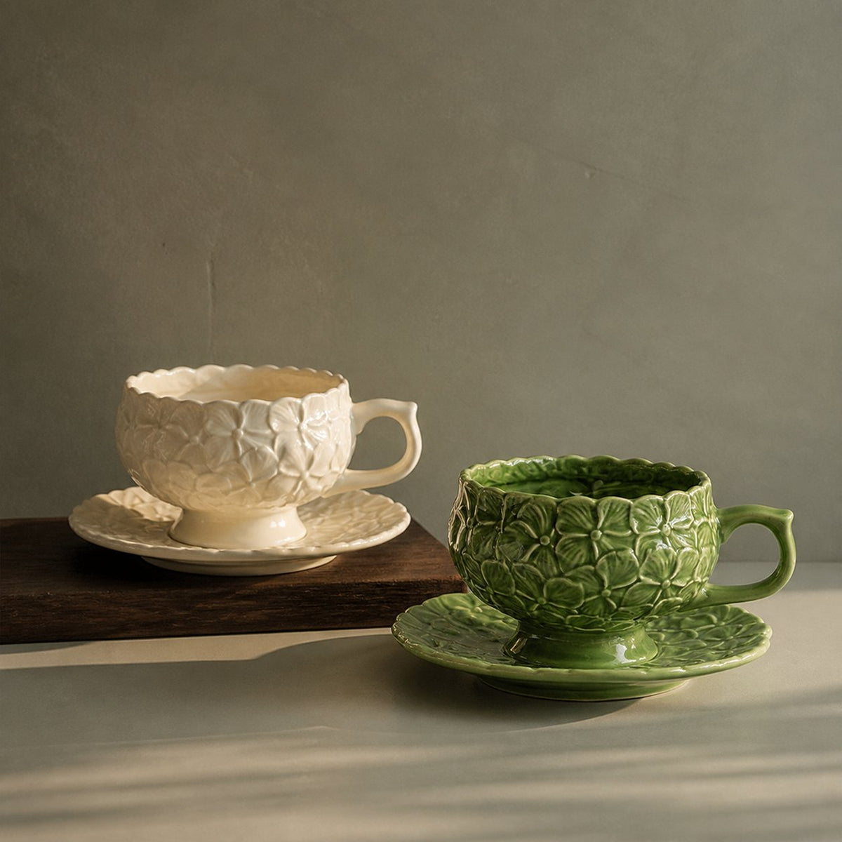 Ivory Bloom and Sage Garden hydrangea relief ceramic cup and saucer sets viewed from the side.