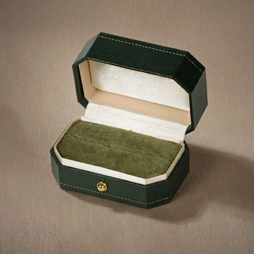 Open green ring box showing the empty green velvet interior and cream satin lid lining