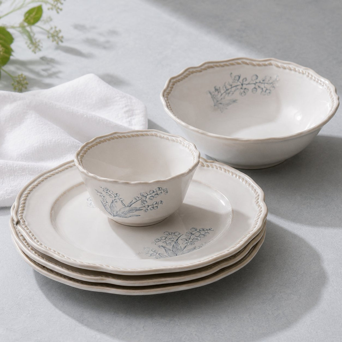 Lily of the Valley ceramic dinnerware stacked detail, close-up of hand-painted floral pattern and darkened scalloped rim