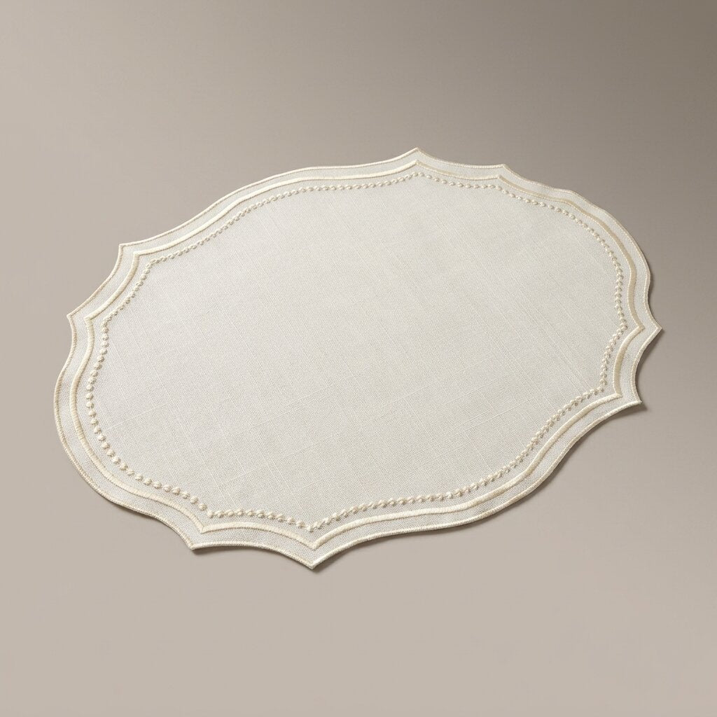 Oval placemat in ivory linen-look fabric with a tone-on-tone cream embroidered wavy edge, product photo